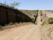 «Coyotes» abandonan a mujer colgando del cerco fronterizo en Nogales